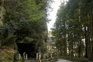 Path adjacent to the shear rock wall with ancient cave shrines.