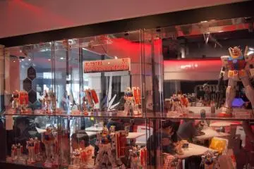 <p>โมเดลพลาสติก (GUNPLA) หลากหลายขนาดวางเรียงรายในตู้โชว์</p>