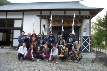 <p>สมาชิกของกองพลปืนไรเฟิลและนักท่องเที่ยวตั้งท่าถ่ายรูปอยู่หน้าห้องโถงของเมือง Sumita&nbsp;</p>