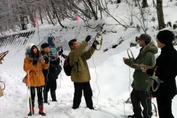 One of the guides explains how to put on the snow shoes.&nbsp;