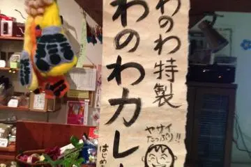 <p>ป้ายหน้าเคาท์เตอร์ เขียนว่า WanoWa Curry แกงกระหรี่สไตส์วาโนวะ</p>
