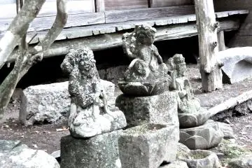 <p>Three very old statues in front of the temple building</p>