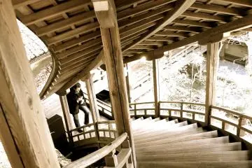 <p>Curved staircase leading up the hill. Everything is connected by covered wooden walkways</p>
